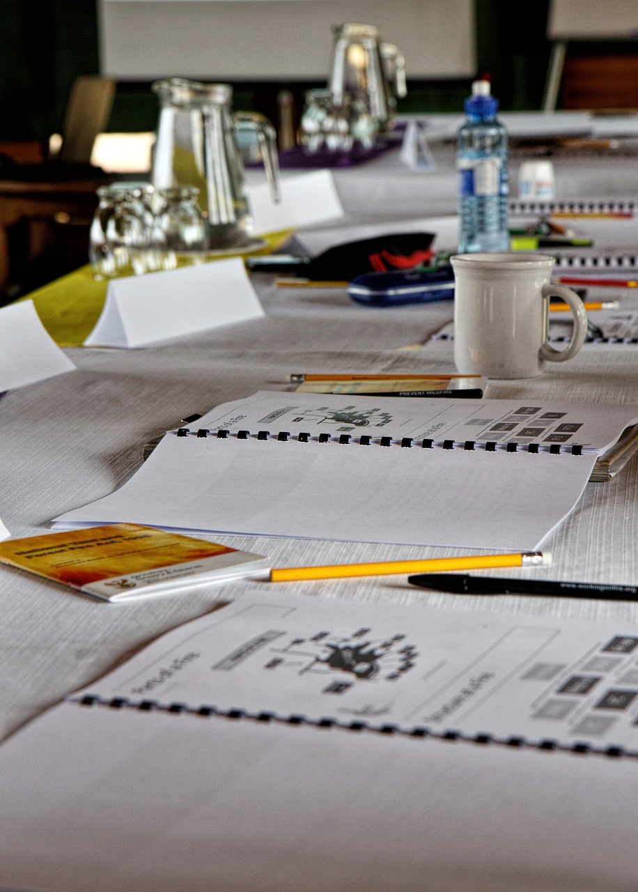 Ein Konferenz- oder Arbeitsmeeting-Tisch mit Notizblock, Stiften und einer Kaffeetasse